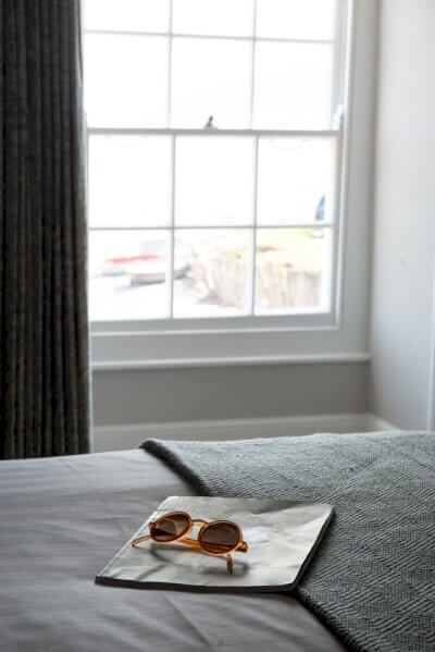 Magazine and sunglasses on bed